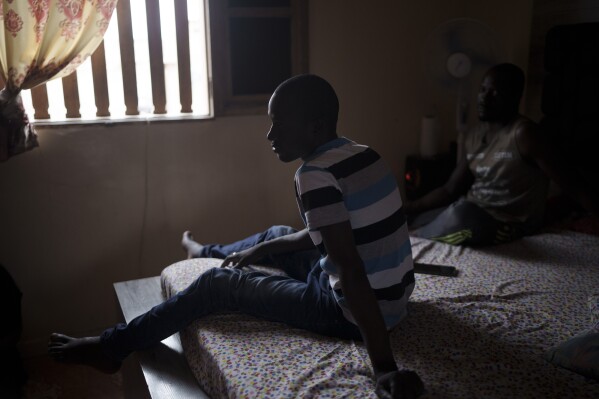 Moustafa Diallo, de 28 años, descansa en una cama en la casa de un amigo en Diogo Sur Mer, Senegal, el lunes 28 de agosto de 2023. (AP Foto/Felipe Dana) 