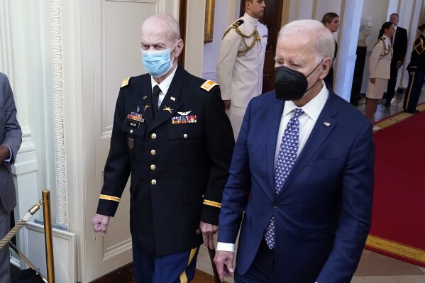 President Joe Biden arrives with Capt. Larry Taylor, an Army pilot from the Vietnam War who risked his life to rescue a reconnaissance team that was about to be overrun by the enemy, to award him the Medal of Honor during a ceremony Tuesday, Sept. 5, 2023, in the East Room of the White House in Washington. (AP Photo/Jacquelyn Martin)
