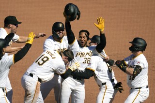 Pittsburgh Pirates' Edward Olivares (38) celebrates after hitting a walk-off fielder's choice off Baltimore Orioles relief pitcher Yennier Cano, driving in two runs during the ninth inning of a baseball game in Pittsburgh, Sunday, April 7, 2024. The Pirates won 3-2. (AP Photo/Gene J. Puskar)