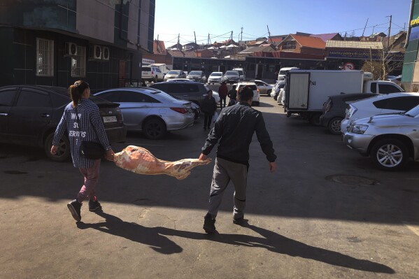 Customers shop for meat at a wholesale market in the Mongolian capital, Ulaanbaatar, on Monday, May 22, 2023. (AP Photo/Manish Swarup)