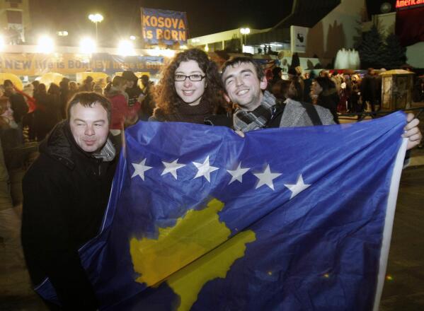 FILE - Kosovars hold the new national flag as they celebrate Kosovo's declaration of independence in the capital, Pristina, on Feb. 17, 2008. Kosovo is celebrating 15 years of independence with a month of celebrations starting Friday while still facing serious challenges with Serbia, which refuses to recognize the autonomy of its former province. Europe's youngest country unilaterally declared independence from Serbia on Feb. 17, 2008, nearly nine years after a 78-day NATO bombing campaign in 1999 ended Belgrade's bloody crackdown on ethnic Albanian separatists. (AP Photo/Visar Kryeziu)