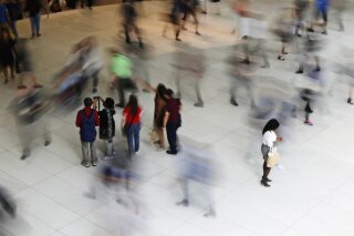 FILE - In this June 15, 2017, file photo, people walk inside the Oculus, the new transit station at the World Trade Center in New York. According to figures released Monday, Dec. 30, 2019, by the U.S. Census Bureau, the past year’s population growth rate in the United States was the slowest in a century due to declining births, increasing deaths and the slowdown of international migration. (AP Photo/Frank Franklin II, File)