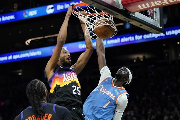 Phoenix Suns forward Mikal Bridges (25) dunks as Los Angeles Clippers guard Reggie Jackson (1) defends during the first half of an NBA basketball game Tuesday, Feb. 15, 2022, in Phoenix. (AP Photo/Matt York)