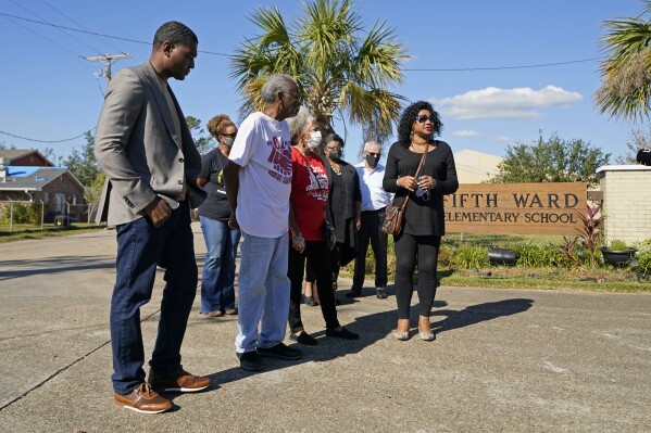 FILE - EPA Administrator Michael Regan, left, arrives at the Fifth Ward Elementary School, which is near the Denka plant, with Robert Taylor, second left, founder of Concerned Citizens of St. John's Parish, and Lydia Gerard, third left, a member of the group, in Reserve, La., Nov. 16, 2021. The Environmental Protection Agency spent more than a year investigating whether Louisiana's oversight of industrial air emissions discriminated against Black residents. The EPA’s investigation ended, however, before it secured commitments from the state to strengthen its oversight. (AP Photo/Gerald Herbert, File)