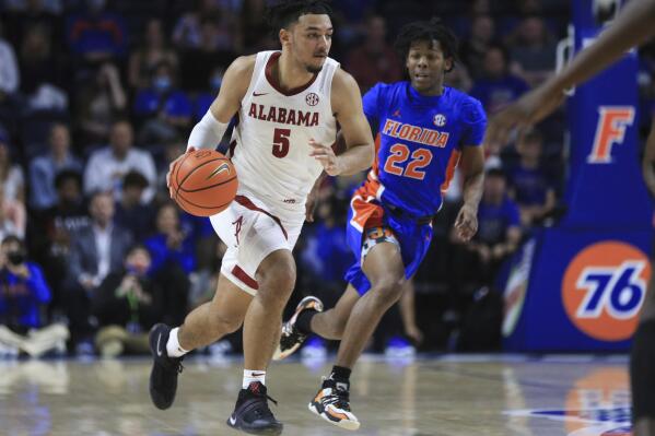 Alabama guard Jaden Shackelford (5) brings the ball up past Florida guard Tyree Appleby (22) during the first half of an NCAA college basketball game Wednesday, Jan. 5, 2022, in Gainesville, Fla. (AP Photo/Matt Stamey)