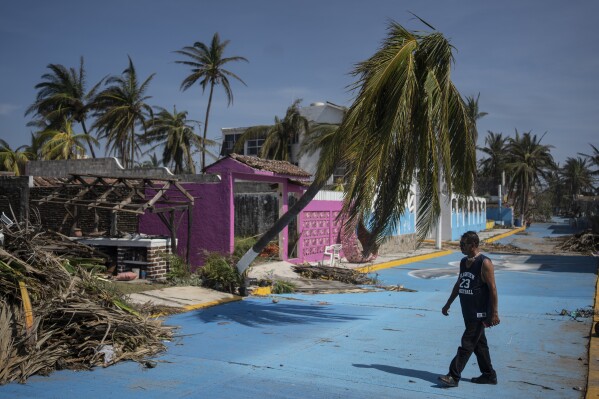 A man walks past at a damaged area in the aftermath of Hurricane Otis in Acapulco, Mexico, Sunday, Oct. 29, 2023. Mexican authorities have raised the toll to 48 dead from the Category 5 storm that struck the country's southern Pacific coast. (AP Photo/Felix Marquez)
