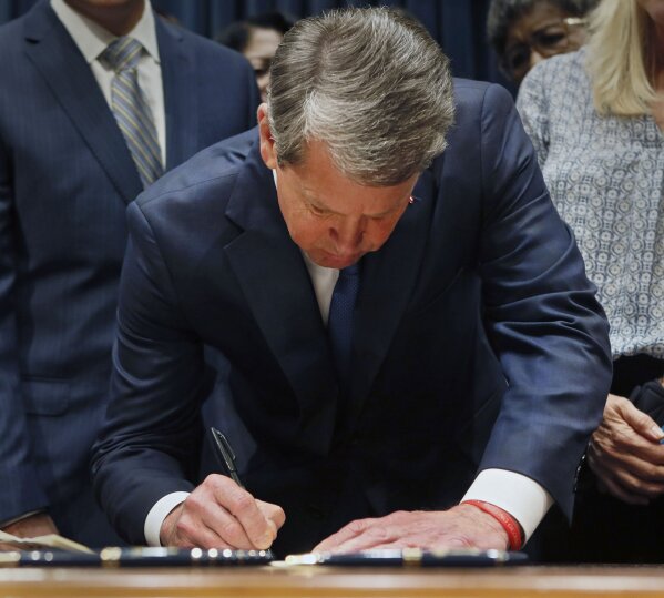 File-This May 7, 2019, file photo shows Georgia's Republican Gov. Brian Kemp signing legislation, in Atlanta, banning abortions once a fetal heartbeat can be detected.  A federal judge on Tuesday, Oct. 1, 2019, temporarily blocked Georgia’s restrictive new abortion law from taking effect, following the lead of other judges who have blocked similar measures in other states. The law signed in May by Republican Gov. Brian Kemp bans abortions once a fetal heartbeat is detected, which can happen as early as six weeks into a pregnancy, before many women realize they’re expecting. It allows for limited exceptions.  (Bob Andres/Atlanta Journal-Constitution via AP, File)