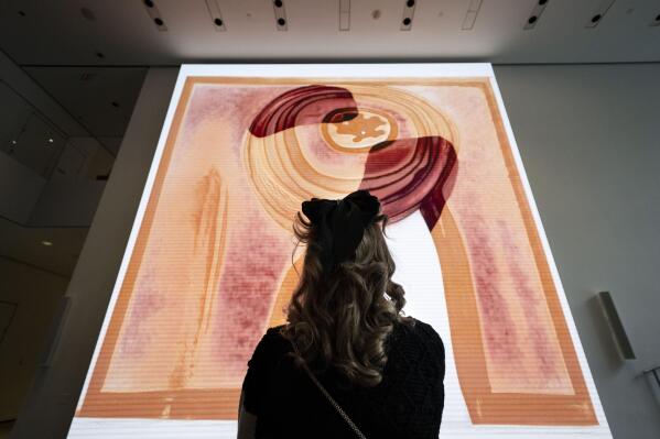 A visitor looks at artist Refik Anadol's "Unsupervised" exhibit at the Museum of Modern Art, Wednesday, Jan. 11, 2023, in New York. The new AI-generated installation is meant to be a thought-provoking interpretation of the New York City museum's prestigious collection. (AP Photo/John Minchillo)