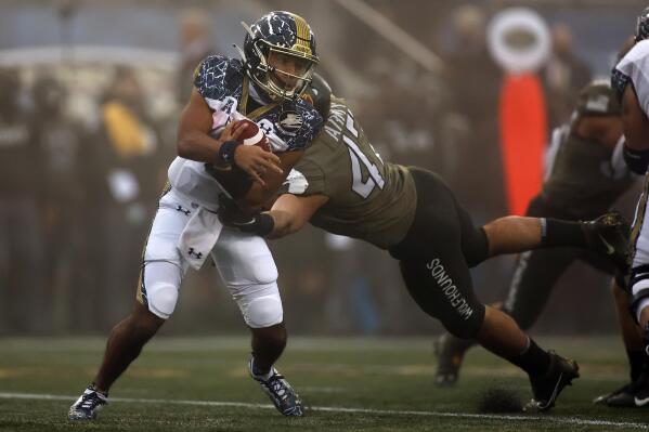 FILE - Navy quarterback Xavier Arline (7) is tackled by Army linebacker Jon Rhattigan (47) during the first half of an NCAA college football game Saturday, Dec. 12, 2020, in West Point, N.Y.  Bowl-bound Army looks to beat Navy for 5th time in 6 games as both teams meet on Saturday, Dec. 11, 2021.  (AP Photo/Adam Hunger)