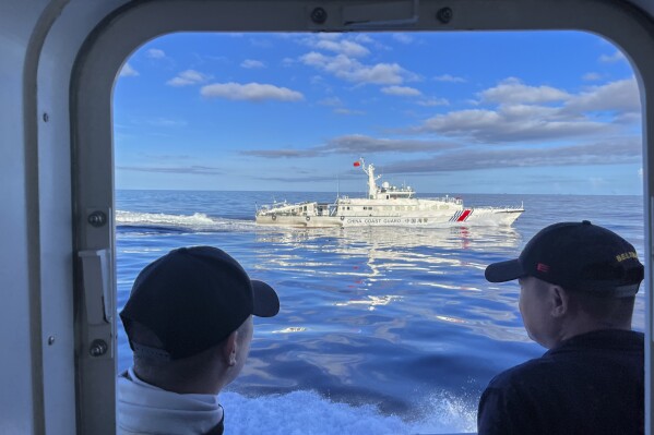 FILE - A Chinese coast guard vessel maneuvers beside the Philippine coast guard ship BRP Cabra as they approach the Second Thomas Shoal, locally known as Ayungin Shoal, during a resupply mission on the disputed South China Sea on Nov. 10, 2023. Chinese coast guard ships blocked Philippine vessels from a disputed South China Sea shoal Tuesday, March 5, 2024, causing a minor collision, Philippine officials said. (AP Photo/Jim Gomez, File)