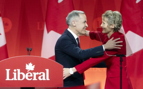 Newly appointed Liberal Leader Mark Carney hugs his wife Diana Fox Carney following his speech at the Liberal leadership announcement in Ottawa, Ontario, Sunday, March 9, 2025. (Adrian Wyld/The Canadian Press via AP)