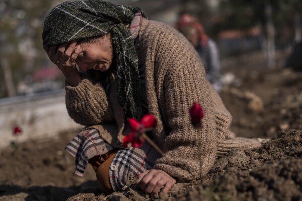 A member of the Vehibe family mourns a relative during the burial of one of the earthquake victims that struck a border region of Turkey and Syria five days ago in Antakya, southeastern Turkey, Feb. 11, 2023. (AP Photo/Bernat Armangue)