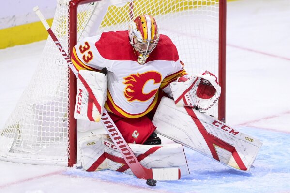 Calgary Flames goaltender David Rittich (33) makes a save on a shot from Ottawa Senators left wing Tim Stutzle, not shown, during the second period of an NHL game in Ottawa, Ontario, on Saturday, Feb. 27, 2021. (Sean Kilpatrick/The Canadian Press via AP)