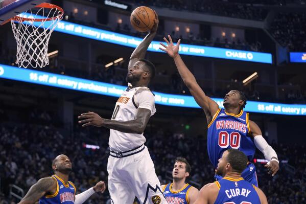 Denver Nuggets forward JaMychal Green, middle, dunks against Golden State Warriors forward Jonathan Kuminga (00) during the first half of an NBA basketball game in San Francisco, Tuesday, Dec. 28, 2021. (AP Photo/Jeff Chiu)