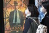 People walk by a poster to promote the movie "Oppenheimer" Friday, March 29, 2024, in Tokyo. “Oppenheimer” finally premiered Friday in the nation where two cities were obliterated 79 years ago by the nuclear weapons invented by the American scientist who was the subject of the Oscar-winning film. Japanese filmgoers' reactions understandably were mixed and highly emotional. (AP Photo/Eugene Hoshiko)