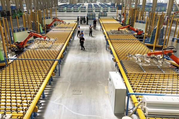 Kuka robots work on the production line of flat glass for solar panels at a subsidiary plant of Hoshine Silicon Industry in northwestern China's Xinjiang Uyghur Autonomous Region Friday, May 24, 2024. Factory activity in China slowed more than expected in May, suggesting further pressure on an economy already burdened by a prolonged crisis in the property industry, according to an official survey released Friday. (Chinatopix Via AP)