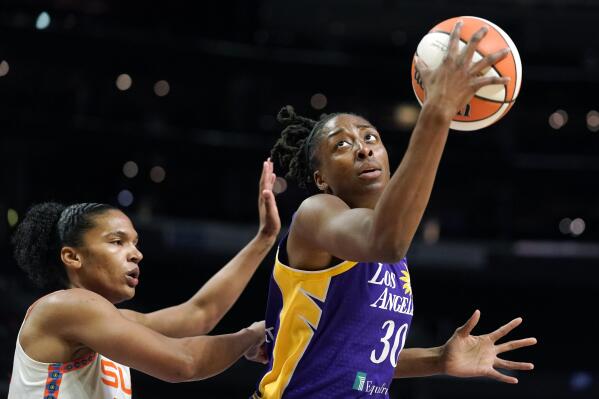 FILE - Los Angeles Sparks forward Nneka Ogwumike, right, tries to shoot as Connecticut Sun forward Alyssa Thomas defends during the first half of a WNBA basketball game Aug. 11, 2022, in Los Angeles. Ogwumike wants to not only restore Los Angeles into a championship contending franchise, but also to get the community excited about basketball and women's sports. (AP Photo/Mark J. Terrill, File)