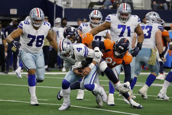 Dallas Cowboys quarterback Dak Prescott (4) is sacked by Denver Broncos' Jonathon Cooper (53) and Stephen Weatherly (91) as Terence Steele (78) and La'el Collins (71) look on in the second half of an NFL football game in Arlington, Texas, Sunday, Nov. 7, 2021. (AP Photo/Michael Ainsworth)