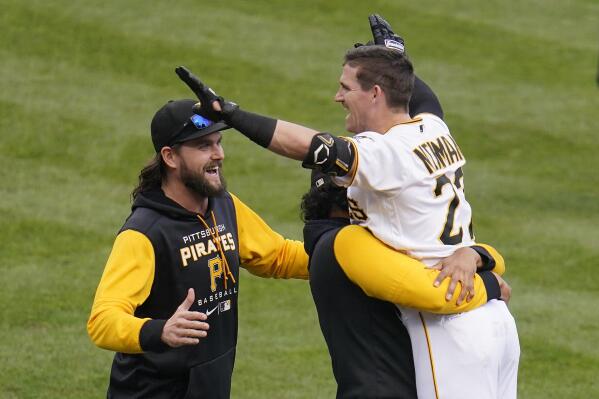Pittsburgh Pirates' Kevin Newman, right, celebrates with teammates after hitting the game-winning RBi single off 
of Cincinnati Reds relief pitcher Alexis Diaz in the 10th inning of a baseball game in Pittsburgh, Wednesday, Sept. 28, 2022. The Pirates won 4-3 in 10 innings. (AP Photo/Gene J. Puskar)