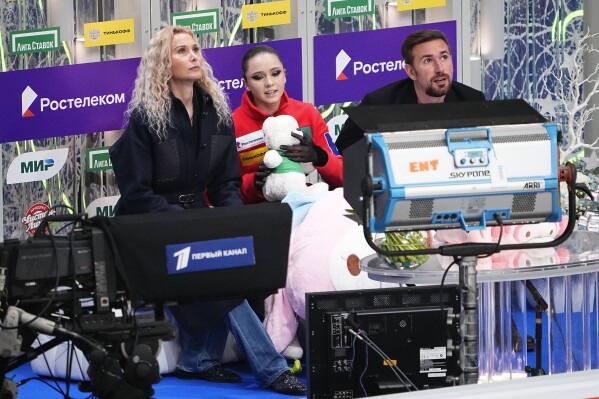 FILE - Russian Kamila Valieva, center, her coach Eteri Tutberidze, left, and choreographer Daniil Gleikhengauz wait for result of her competing in the women's free skate program during the figure skating competition at the 2022 Russian Figure Skating Grand Prix, the Golden Skate of Moscow, at Megasport Arena in Moscow, Russia, on Oct. 23, 2022. The doping case of teenage Russian figure skater Kamila Valieva that shocked the 2022 Beijing Olympics returns to the highest court in sports on Tuesday, Sept. 26, 2023. (AP Photo/Alexander Zemlianichenko)