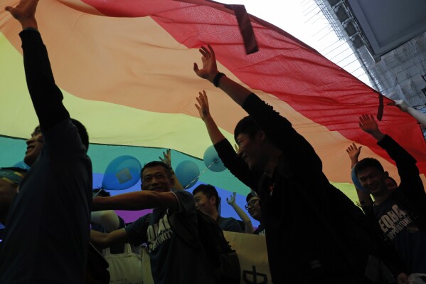 FILE - Participants raise a rainbow flag, a symbol of the gay rights movement during the annual Gay Pride Parade in Hong Kong on Nov. 25, 2017. A Hong Kong court on Tuesday, Oct. 24, 2023, upheld a ruling that favored the granting of equal inheritance rights to same-sex couples, in the latest victory for the city's LGBTQ+ community. (AP Photo/Vincent Yu, File)