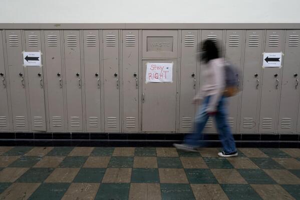 A student walks between classes at Wyandotte High School in Kansas City, Kan., on the first day of in-person learning Wednesday, March 30, 2021. The school, like other schools nationwide, has made extra efforts to keep kids at risk of dropping out engaged as classes went virtual due to the pandemic. (AP Photo/Charlie Riedel)