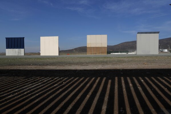
              FILE - In this Wednesday, Dec. 12, 2018, file photo, border wall prototypes stand in San Diego near the Mexico-U.S. border, seen from Tijuana, Mexico, where the current wall casts a shadow in the foreground. (AP Photo/Moises Castillo, File)
            