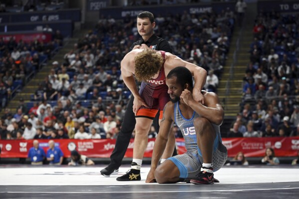 Trent Hidlay, left, consoles Mark Hall, right, after an 86-kilogram match at the U.S. Olympic Wrestling Team Trials in State College, Pa., on Saturday, April 20, 2024. Hidlay won the bout 9-4. (AP Photo/Jackson Ranger)