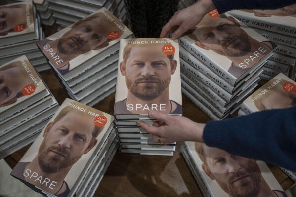 A member of staff places the copies of the new book by Prince Harry called "Spare" at a book store in London, Tuesday, Jan. 10, 2023. Prince Harry's memoir "Spare" went on sale in bookstores on Tuesday, providing a varied portrait of the Duke of Sussex and the royal family. (AP Photo/Kin Cheung)