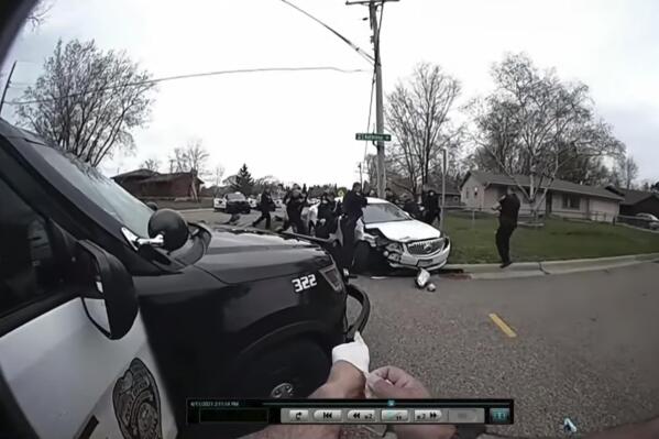 CORRECTS TO BODY CAM OF BROOKLYN CENTER POLICE OFFICER JEFFREY SOMMERS, NOT CHAMPLIN POLICE OFFICER DANIEL IRISH - In this image taken from Brooklyn Center Police Officer Jeffrey Sommers' police body cam video that was played during the trial of former Brooklyn Center police Officer Kim Potter on Thursday, Dec. 9, 2021, in Minneapolis, police approach the car that Daunte Wright was driving after being shot during a traffic stop. Potter, who is white, is charged with first- and second-degree manslaughter in the shooting of Wright, a Black motorist, in the suburb of Brooklyn Center. Potter has said she meant to use her Taser – but grabbed her handgun instead – after Wright tried to drive away as officers were trying to arrest him.  (Court TV, via AP, Pool)