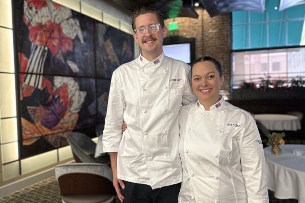 Bradley Waddle, left, stands with Stefani De Palma at Emeril’s restaurant in New Orleans, Thursday, June 13, 2024. De Palma is the head chef and Waddle is the commis chef for Team USA at the Bocuse d’Or Americas culinary competition in New Orleans this week. (AP Photo/Stephen Smith)