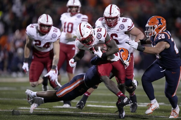Nebraska running back Emmett Johnson carries the ball as Illinois defensive back Nicario Harper makes the tackle during the second half of an NCAA college football game Friday, Oct. 6, 2023, in Champaign, Ill. (AP Photo/Charles Rex Arbogast)