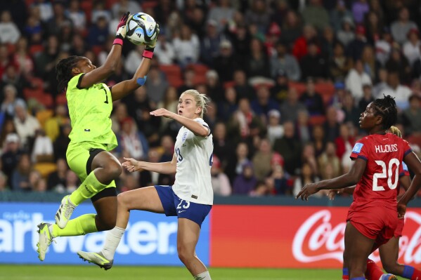 Haiti's goalkeeper Kerly Theus, left, claims a cross ahead of England's Alessia Russo during the Women's World Cup Group D soccer match between England and Haiti in Brisbane, Australia, Saturday, July 22, 2023. (AP Photo/Tertius Pickard)
