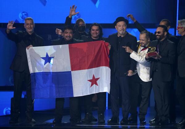 Ruben Blades, third from right, Roberto Delgado, right, and his orchestra accept the award for album of the year for "Salswing!" while holding up the flag of Panama at the 22nd annual Latin Grammy Awards on Thursday, Nov. 18, 2021, at the MGM Grand Garden Arena in Las Vegas. (AP Photo/Chris Pizzello)