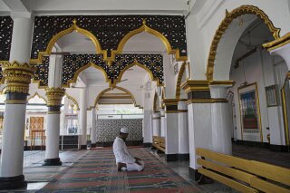 An Indian Muslim man prays in a Mosque during the nationwide lockdown to prevent the spread of new coronavirus in Gauhati, India, Monday, April 27, 2020. The U.S. Commission on International Religious Freedom is urging that the State Department add India to its list of nations with uniquely poor records on protecting freedom to worship, while proposing to remove Sudan and Uzbekistan from that list. (AP Photo/Anupam Nath)