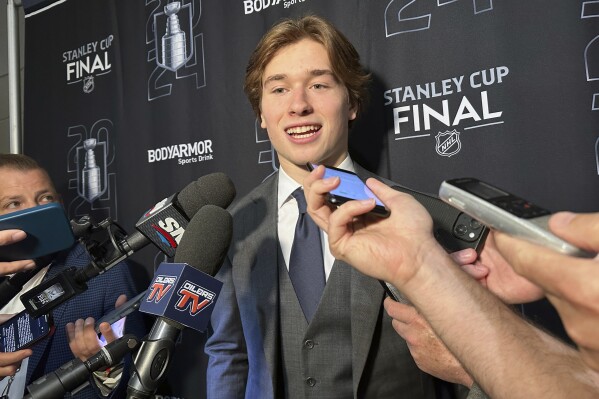 Macklin Celebrini, the expected No. 1 pick in the NHL draft to the San Jose Sharks, speaks with reporters prior to Game 2 of the Stanley Cup Final at Amerant Bank Arena in Sunrise, Florida, Monday, June 10, 2024. (AP Photo/Stephen Whyno)