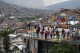 Tourists take photos in the Comuna 13 neighborhood of Medellin, Colombia, Friday, Feb. 2, 2024. Once a battleground for fighting among drug cartels, leftist guerrillas, military forces and government-linked paramilitary groups, the area is now a tourist attraction. (AP Photo/Fernando Vergara)