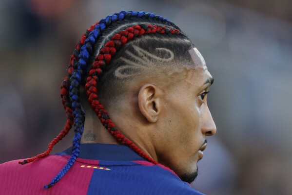 Barcelona's Raphinha challenges during the Spanish La Liga soccer match between Barcelona and Villarreal at Lluis Companys Olympic Stadium in Barcelona, Spain, Sunday, May 18, 2025. (AP Photo/Joan Monfort)