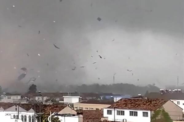 In this frame taken from a video, debris scatters in the sky after a tornado swept through houses in Suqian city in eastern China's Jiangsu Province on Tuesday, Sept. 19, 2023. Two tornadoes within hours killed and injured several people in eastern China, state media said Wednesday. (Zhang via AP)