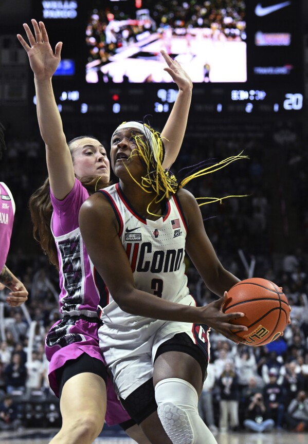 UConn forward Aaliyah Edwards (3) eyes the basket while defended by Georgetown forward Graceann Bennett (33) during the second half of an NCAA college basketball game Friday, Feb. 16, 2024, in Storrs, Conn. (Cloe Poisson/Hartford Courant via AP)