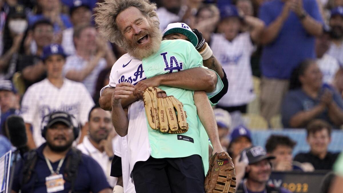 Rapper and Singer Bad Bunny, right, talks to former Los Angeles Dodgers  player Shawn Green during the MLB All Star Celebrity Softball game,  Saturday, July 16, 2022, in Los Angeles. (AP Photo/Mark