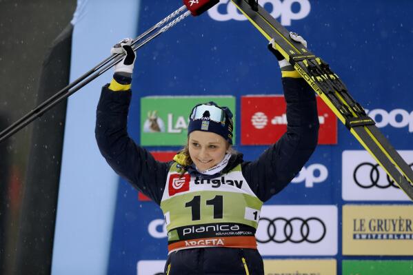 FILE - Second placed Sweden's Stina Nilsson celebrates on the podium after the cross-country ski, women's World Cup sprint event, in Planica, Slovenia, Dec. 21, 2019. Nilsson was at the top of her game after winning four medals at the 2018 Winter Olympics and two World Championship titles in 2019. But Nilsson shocked the Nordic community when she announced in 2020 that she was leaving one of the strongest cross country teams in the world to try her hand at biathlon. (AP Photo/Darko Bandic, File)