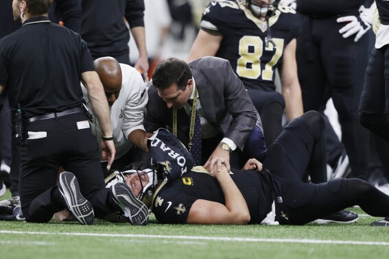 Medical personnel look over New Orleans Saints quarterback Derek Carr (4) after being tackled during the second half of an NFL football game against the Detroit Lions, Sunday, Dec. 3, 2023, in New Orleans. (APPhoto/Butch Dill)