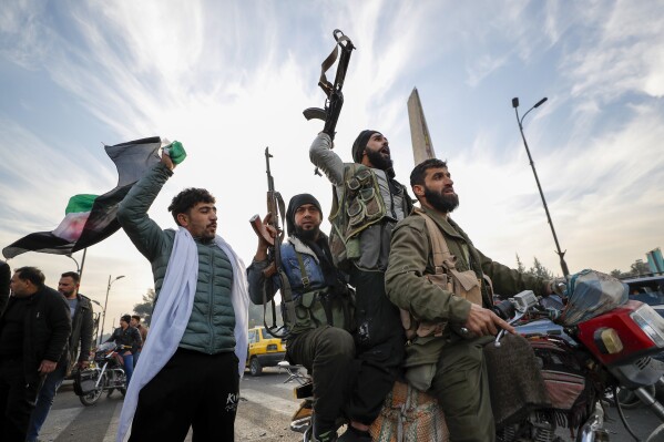 Syrian opposition fighters celebrate after the Syrian government collapsed in Damascus, Syria, Sunday, Dec. 8, 2024. (AP Photo/Omar Sanadiki, File)