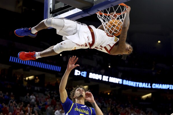 Iowa State's Keshon Gilbert dunks as South Dakota State's Zeke Mayo, bottom, watches during the first half of a first-round college basketball game in the NCAA Tournament Thursday, March 21, 2024, in Omaha, Neb. (AP Photo/John Peterson)