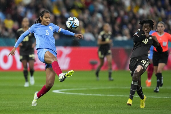 France's Wendie Renard, left, shoots the ball next to Jamaica's Jody Brown during the Women's World Cup Group F soccer match between France and Jamaica at the Sydney Football Stadium in Sydney, Australia, Sunday, July 23, 2023. (AP Photo/Rick Rycroft)