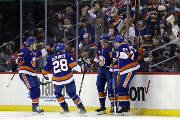 New York Islanders center Brock Nelson, center, is congratulated by teammates after scoring a goal against the New Jersey Devils during the first period of an NHL hockey game Friday, Dec. 9, 2022, in Newark, N.J. (AP Photo/Adam Hunger)