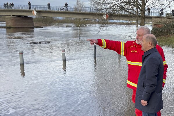 Chancellor Olaf Scholz talks to Karsten Hauschild from the DLRG in the flood area in Verden, Germany, Sunday, Dec. 31, 2023. Scholz took a sightseeing flight in an air force helicopter to get an impression of the flood situation in the north of Lower Saxony. (Arne von Brill/dpa via AP)