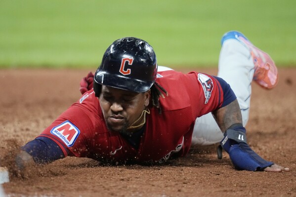 Cleveland Guardians' Jose Ramírez dives safely back to first base on a pickoff attempt during the fifth inning of the team's baseball game against the Baltimore Orioles, Thursday, Sept. 21, 2023, in Cleveland. (AP Photo/Sue Ogrocki)