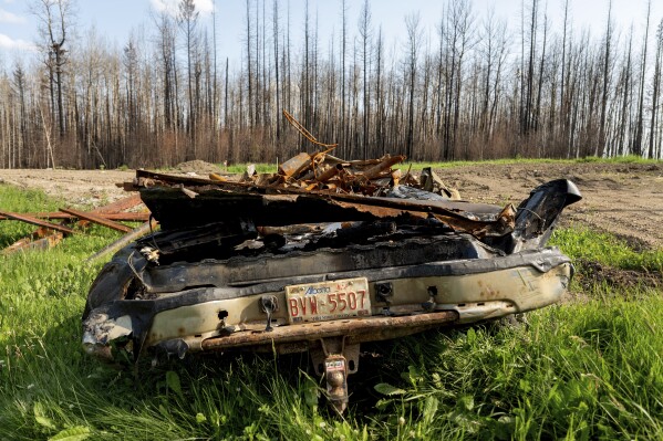 A scorched car rests in the yard of a home destroyed by a wildfire in the East Prairie Metis Settlement Alberta on Tuesday July 4 2023 The settlement whose residents trace their ancestry to European and Indigenous people lost at least 14 homes during the May wildfire according to Chair Raymond Supernault AP PhotoNoah Berger